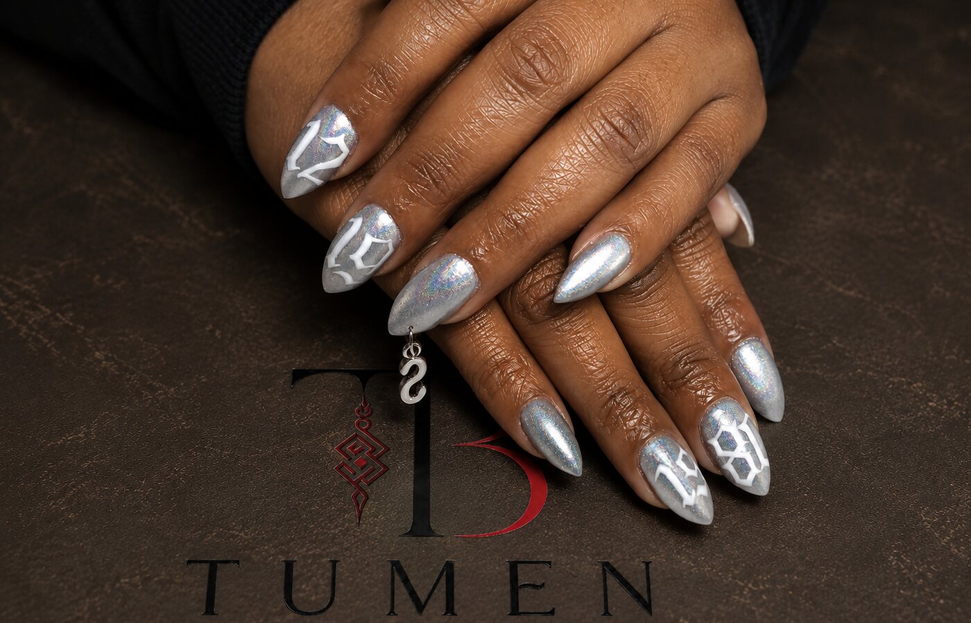 Almond nails in holographic silver chrome finished with a nail charm