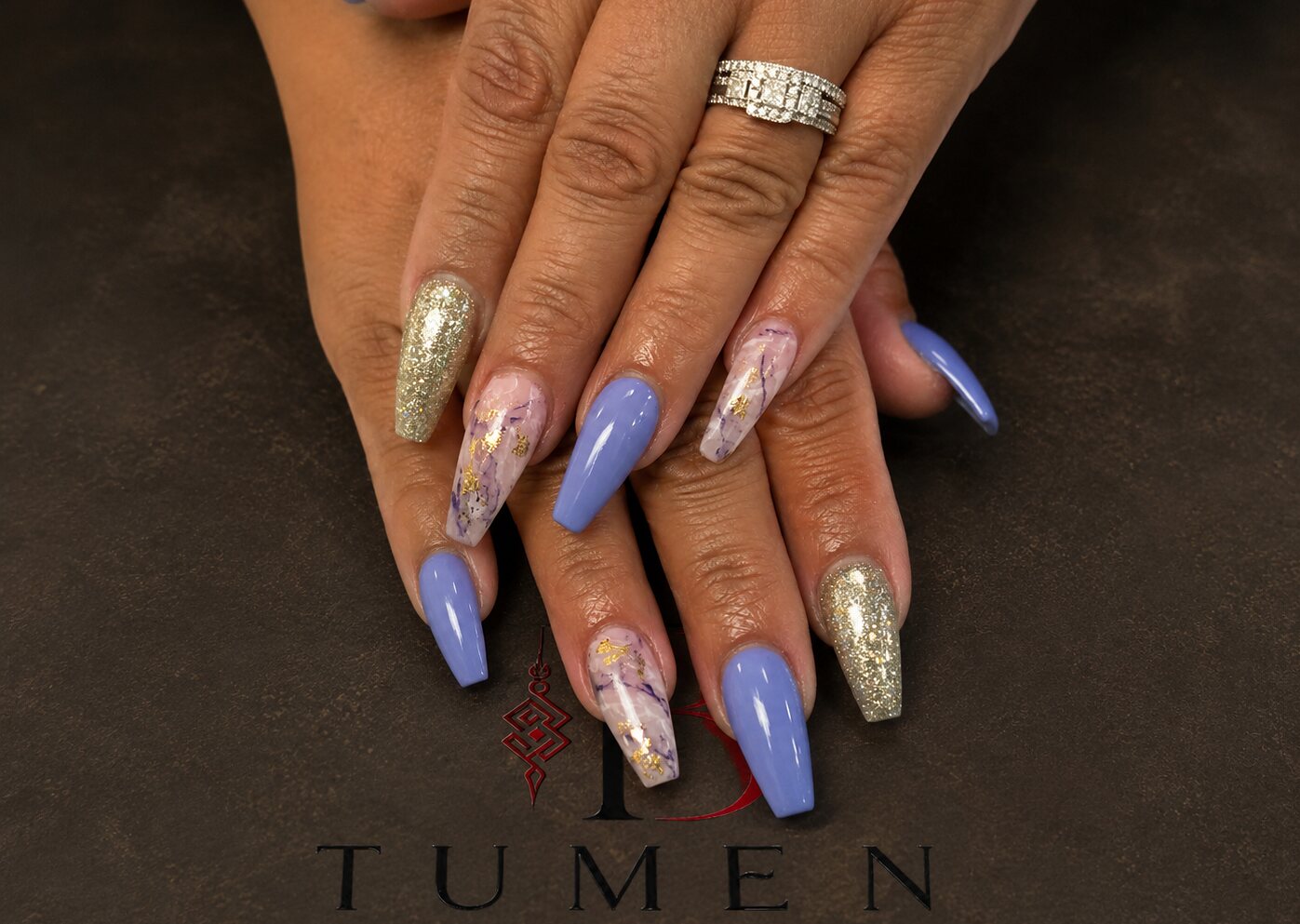 Long coffin nails with marble work, purple color and a gold glitter accent