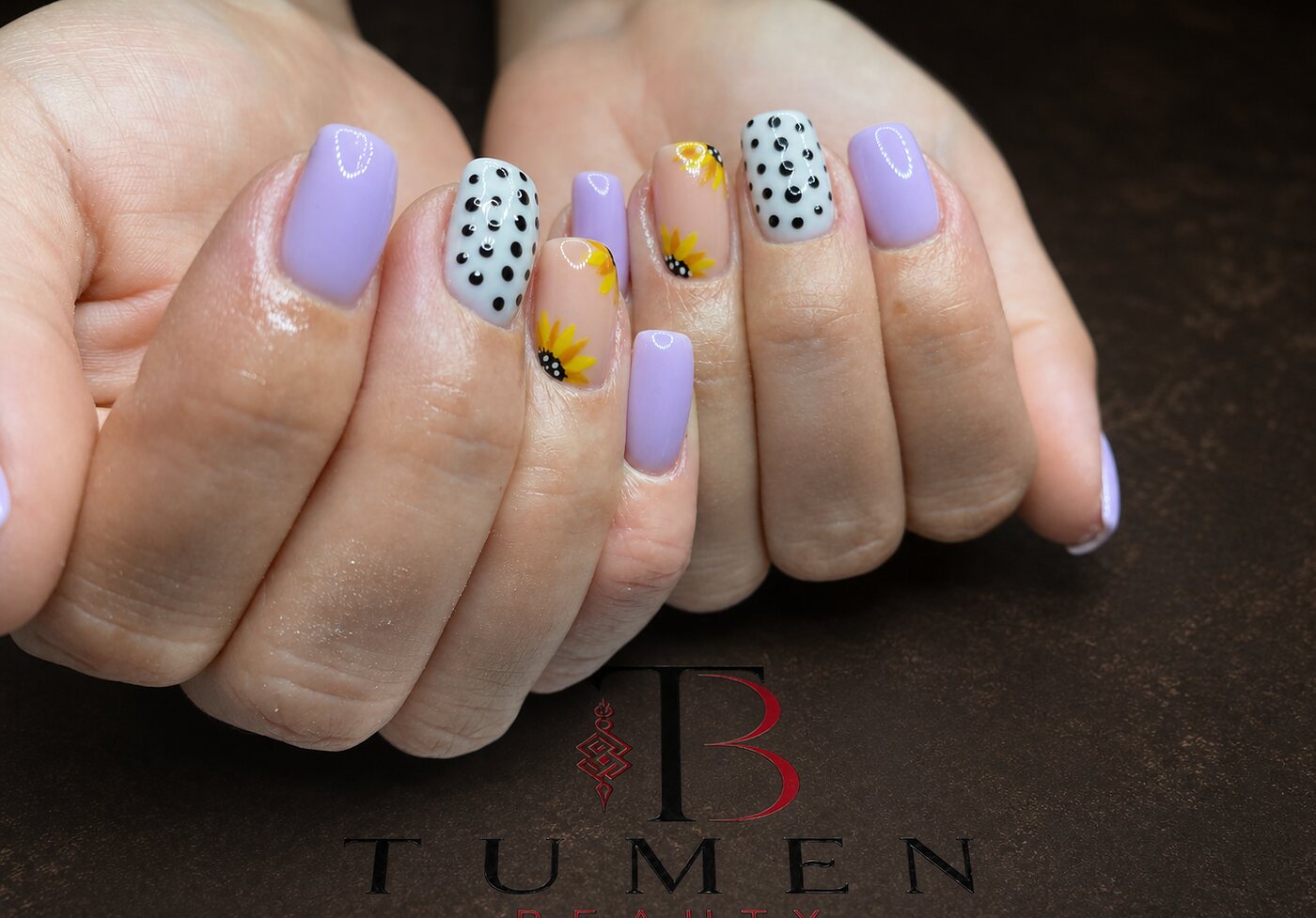 Lilac nails hand-painted with a sunflower and black polka dots